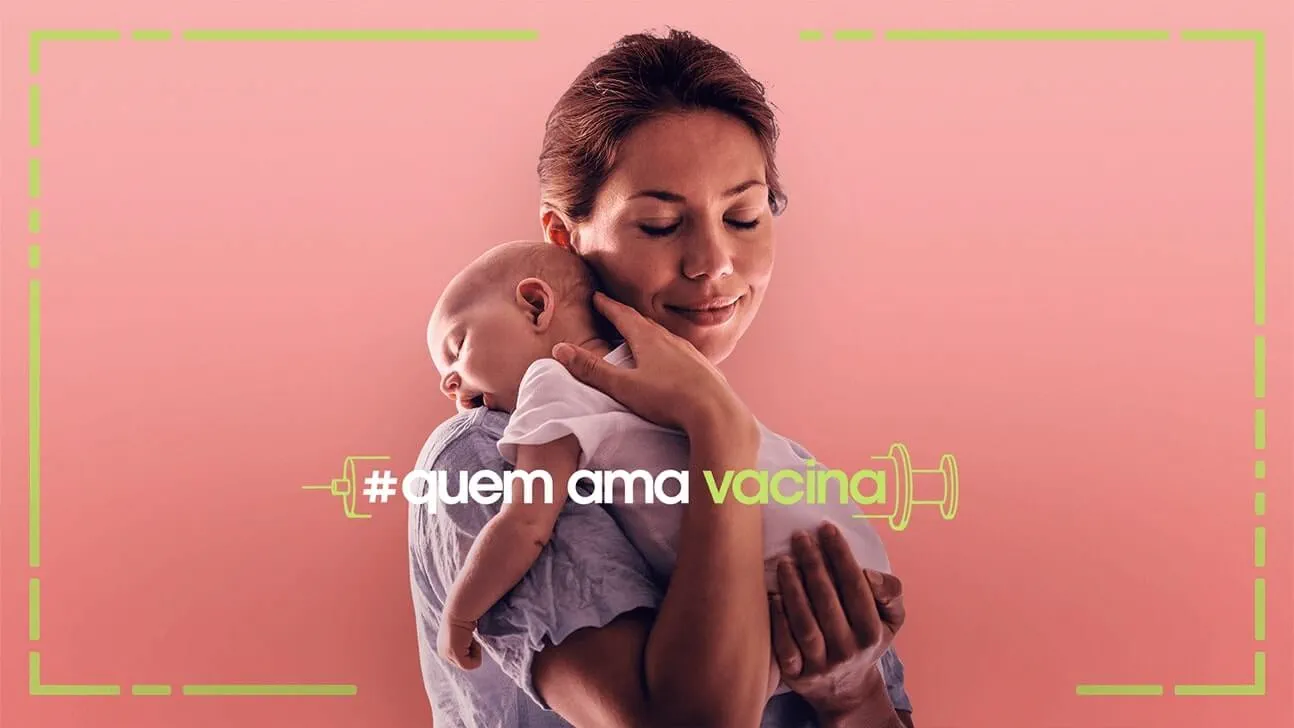 Mulher segurando bebê prematuro no colo com as mãos em suas costas e bumbum