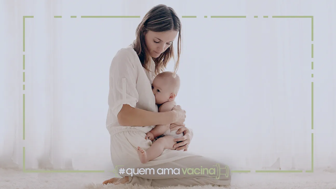 Vacina e amamentação: mãe em pé amamentando bebê.