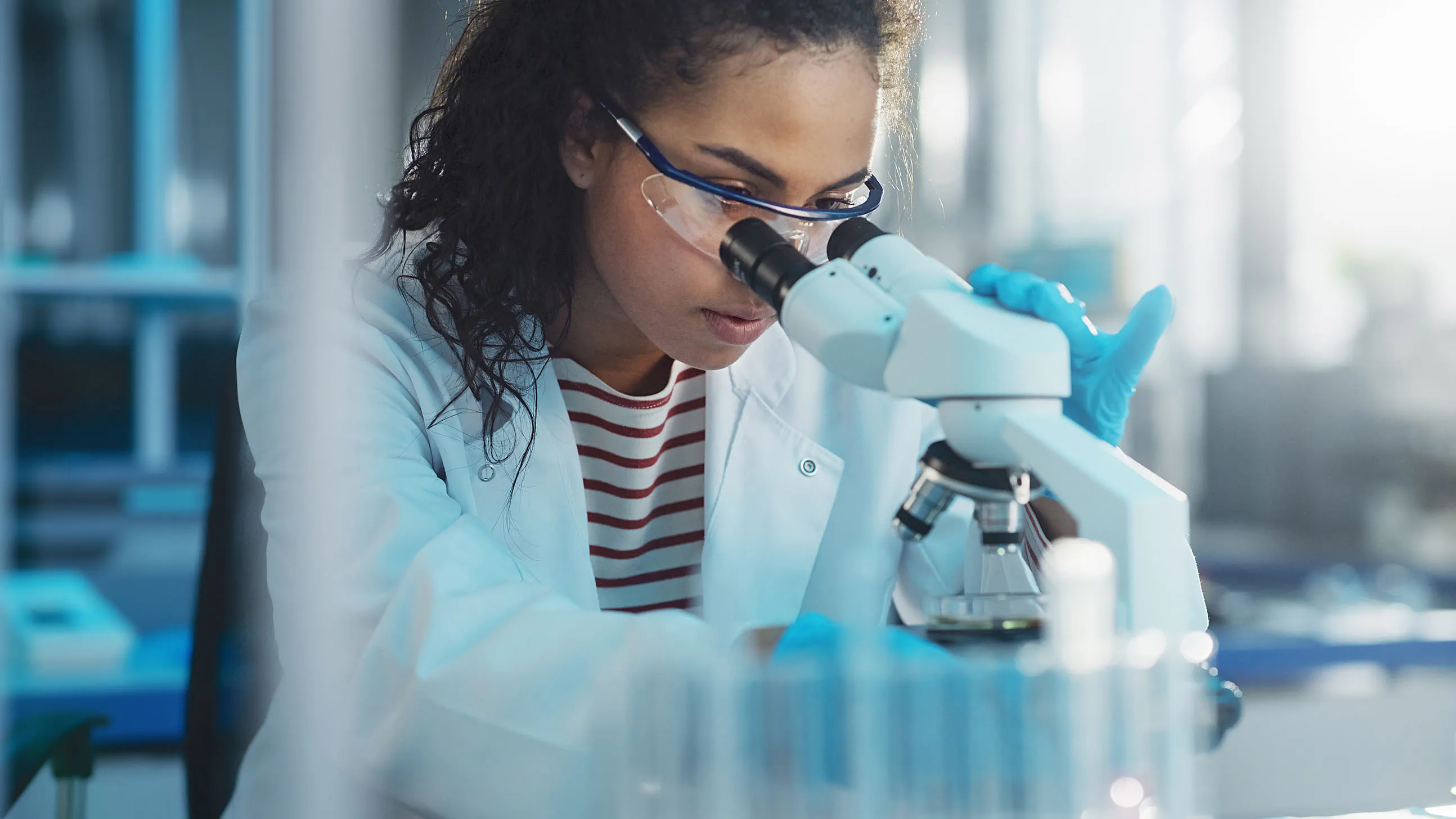 Biomédica analisando microscópio