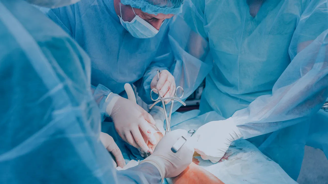 Médicos realizando procedimento cirúrgico na perna do paciente